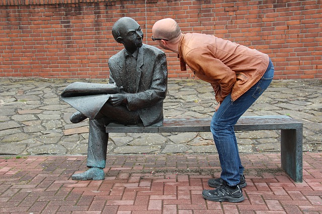 Man facing a statue that looks like a copy him.