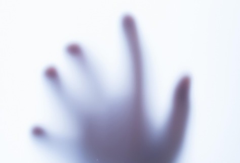 Zombie hand reaching through a foggy window to represent startups stuck after blitzscaling.